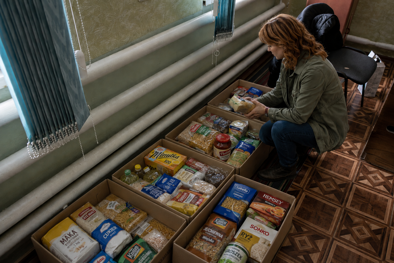 Volunteer sorting packaged food into boxes for Care4Ukraine distribution