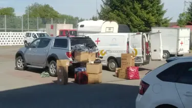Aid vehicles and donated supplies prepared for community support in Ukraine.